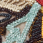Close-up of an intricately beaded and embroidered necklace with a white background